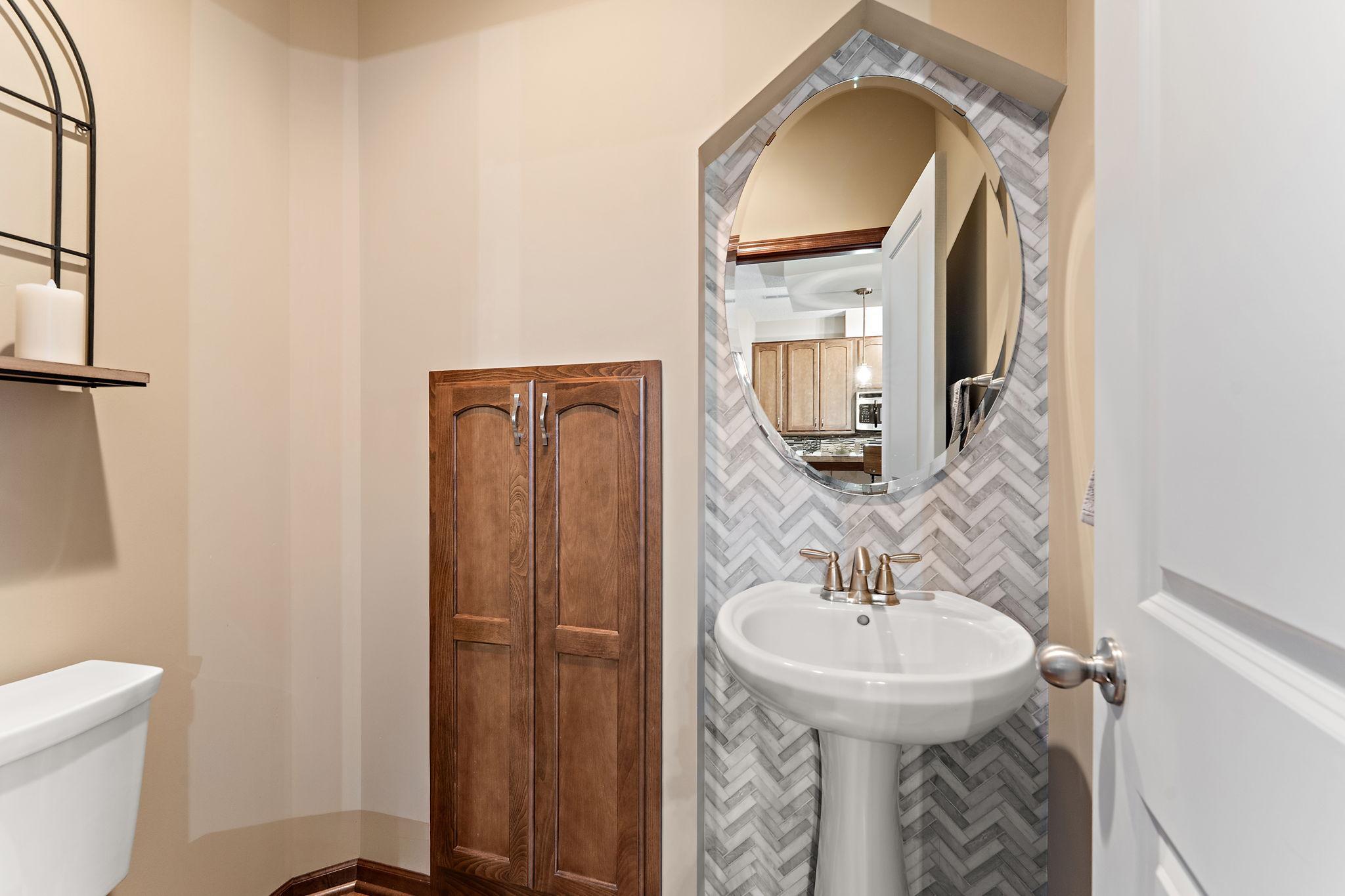 Main floor 1/2 bath with custom tile wall.
