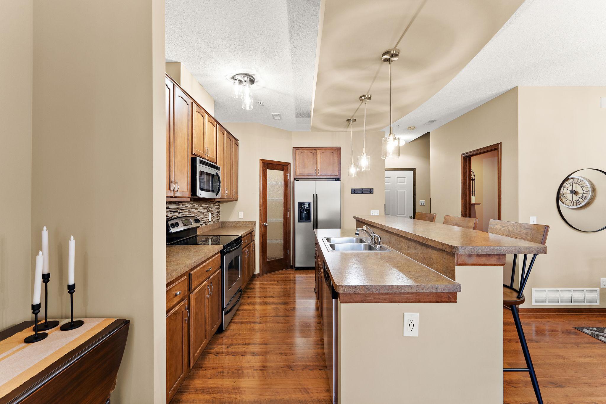 Stainless appliances and a work island with breakfast bar.
