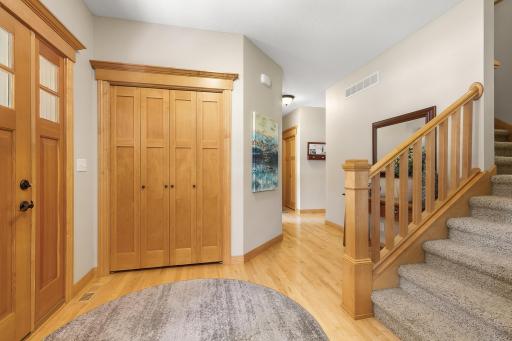 Foyer splits off into the front living room, access to upper level, and a hallway to the kitchen.