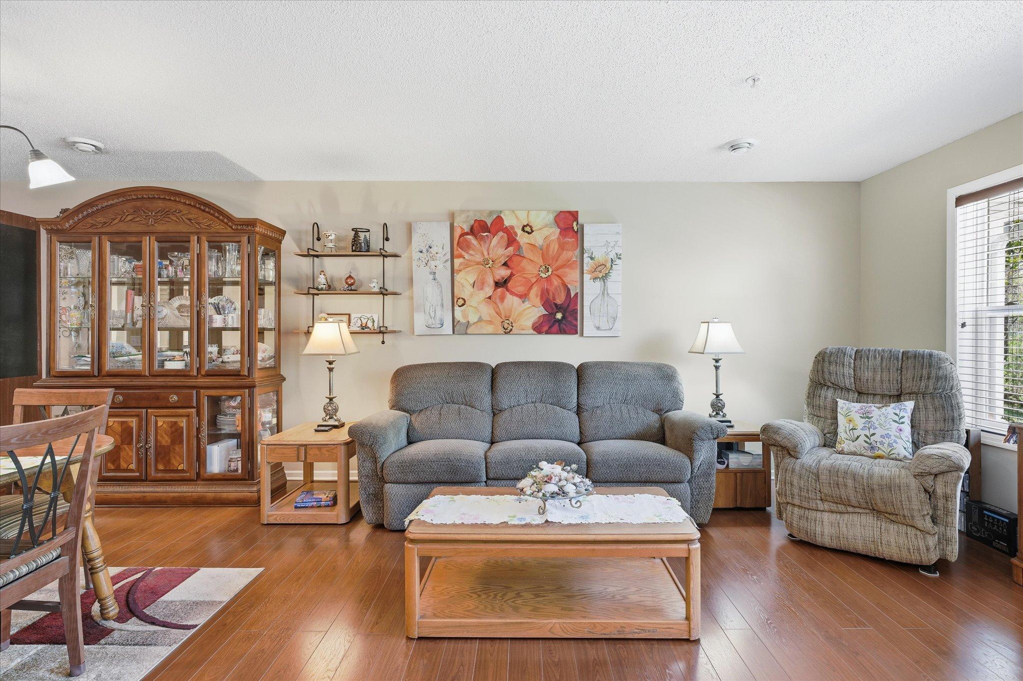 Bright and comfortable living room with large windows, hardwood flooring, and plenty of space for everyday living and entertaining.