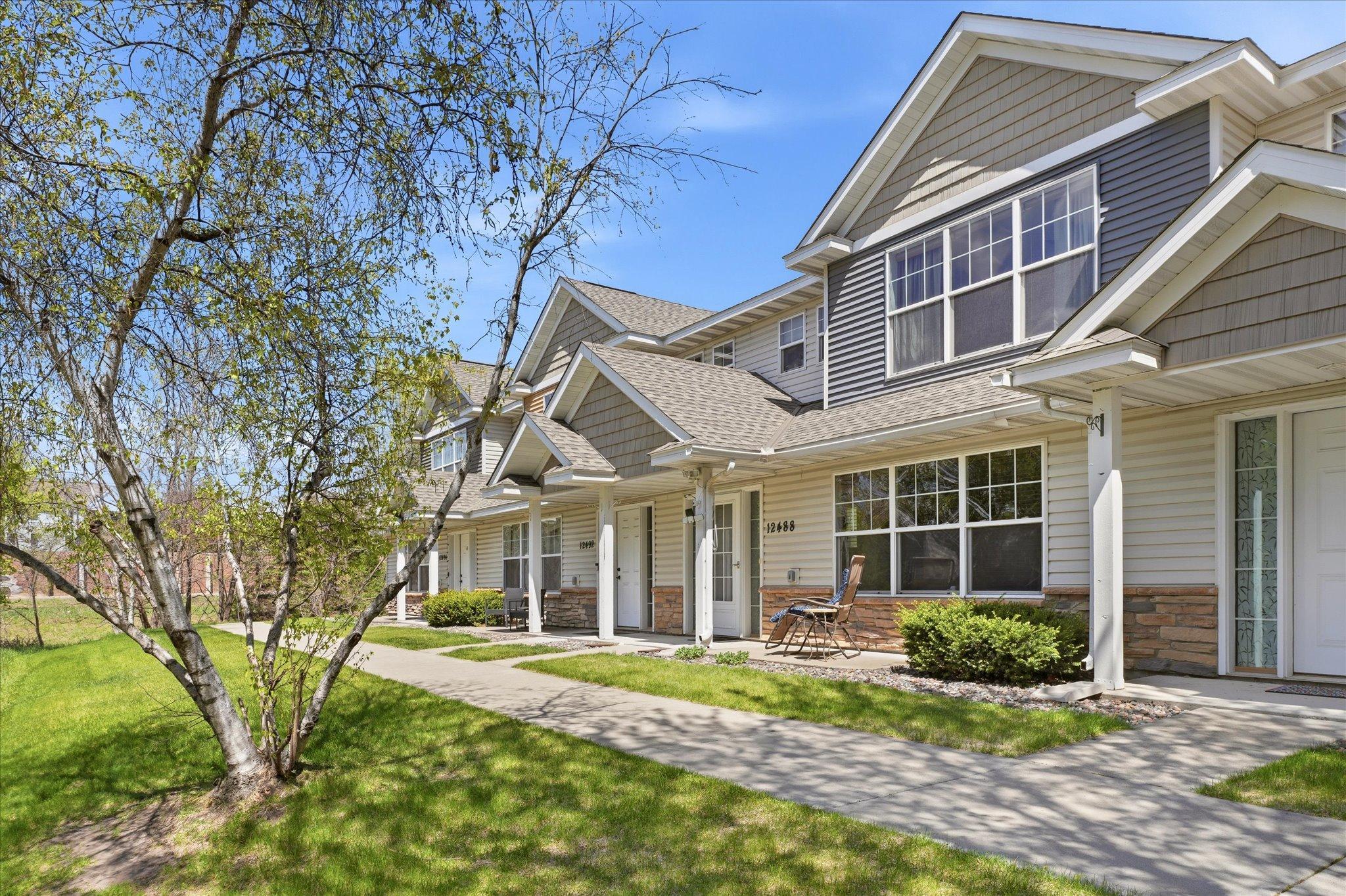 Charming front exterior featuring maintenance-free siding, stone accents, and a welcoming covered entry.