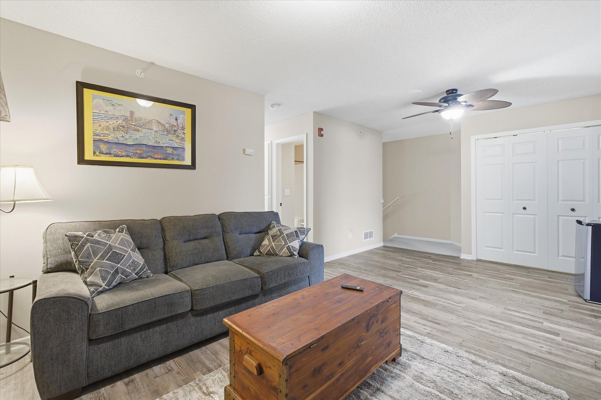 Spacious upper-level family room/loft with modern LVP flooring, a updated ceiling fan, and easy access to the bedrooms and upper-level bath.