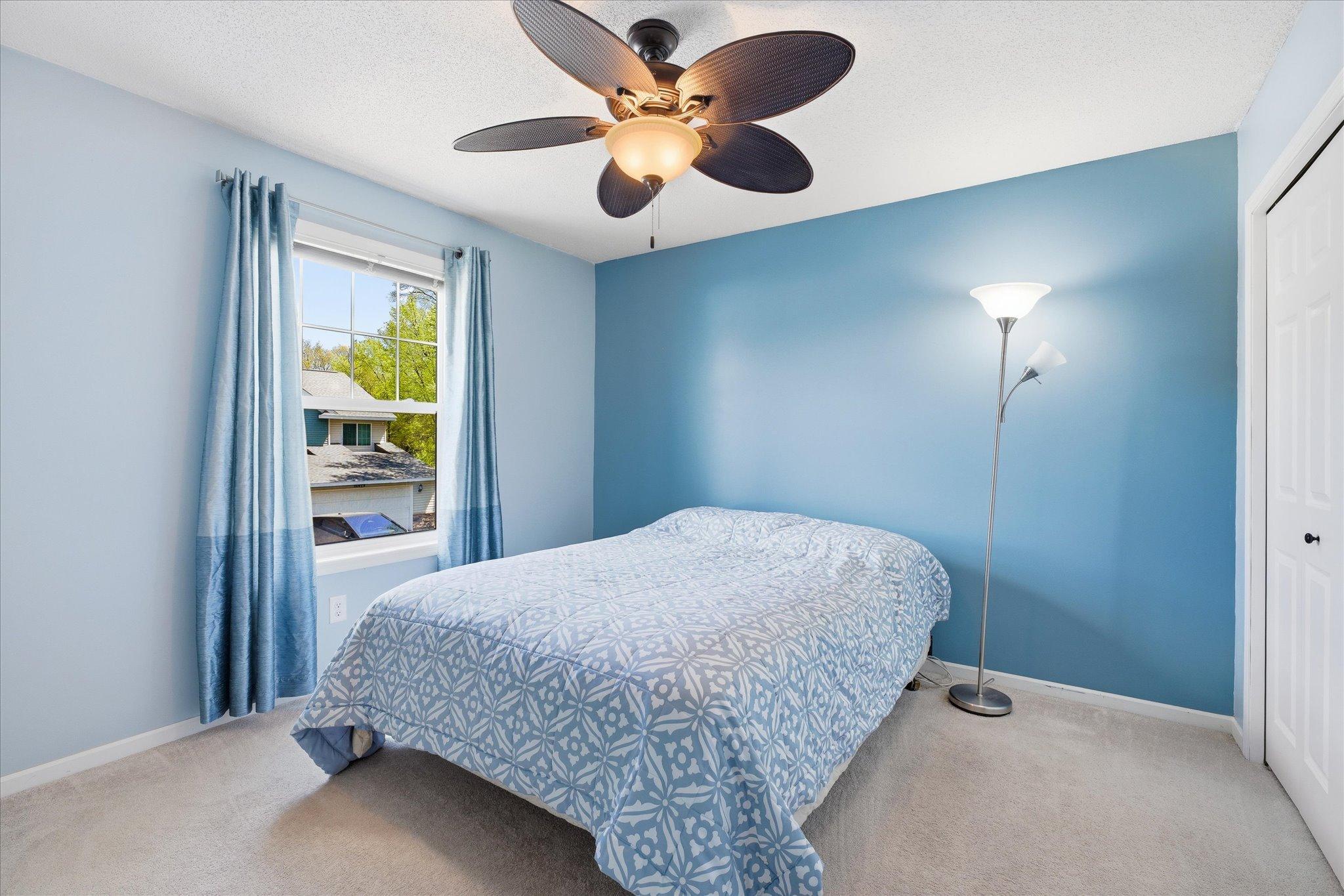 Spacious bedroom #3 featuring soft neutral carpet, calming blue accent walls, and abundant natural light.