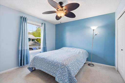 Spacious bedroom #3 featuring soft neutral carpet, calming blue accent walls, and abundant natural light.