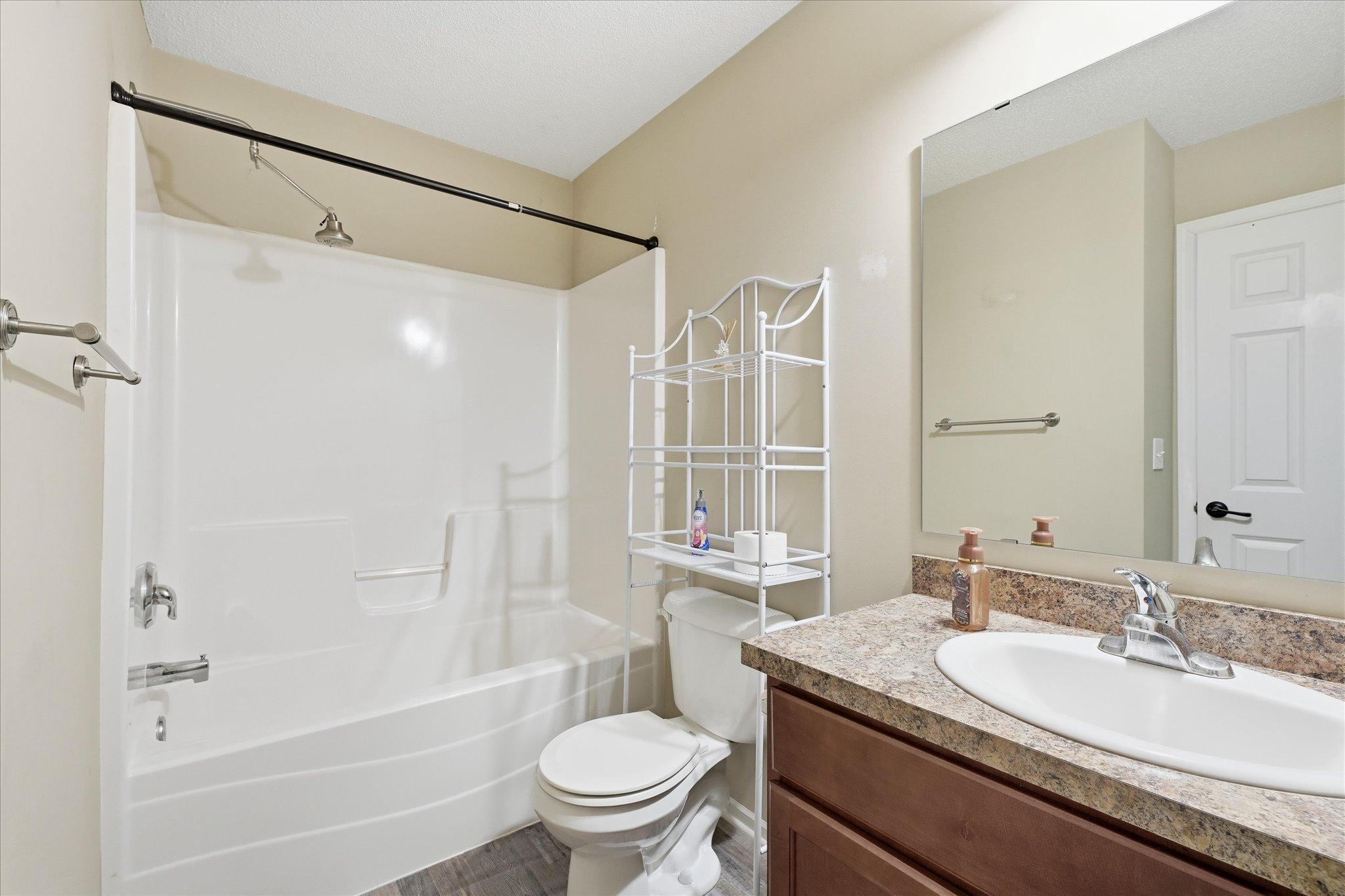 Full upper-level bathroom featuring updated vanity cabinetry, durable LVP flooring, and convenient tub/shower combination.