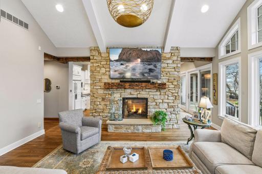 The inviting fireplace features floor-to-ceiling stone and an Indiana limestone hearth.