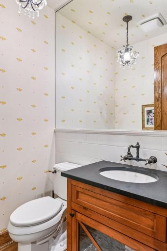 The Powder Room is bright and charming with designer wall coverings and fixtures.