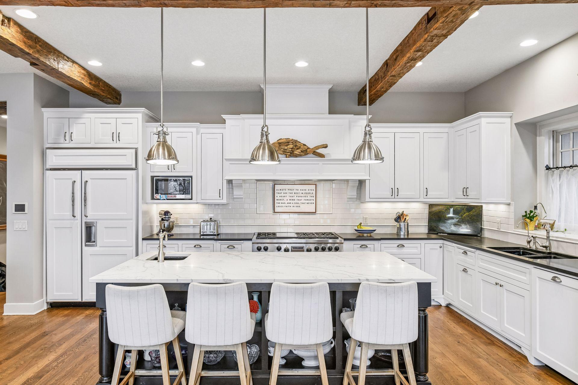 The large island is topped with new quartz countertops and features designer pendant lighting.