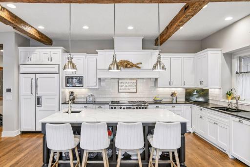 The large island is topped with new quartz countertops and features designer pendant lighting.
