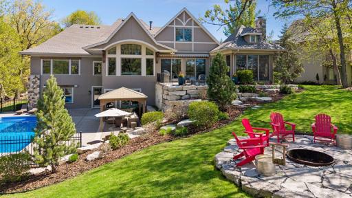The home is surrounded by professional landscaping with custom hewn stonework, paver patios and beautiful garden beds.