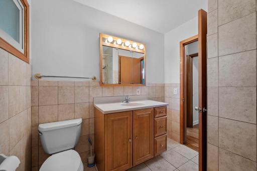 A Nicely appointed full bath on the main floor features ceramic tile and a large vanity
