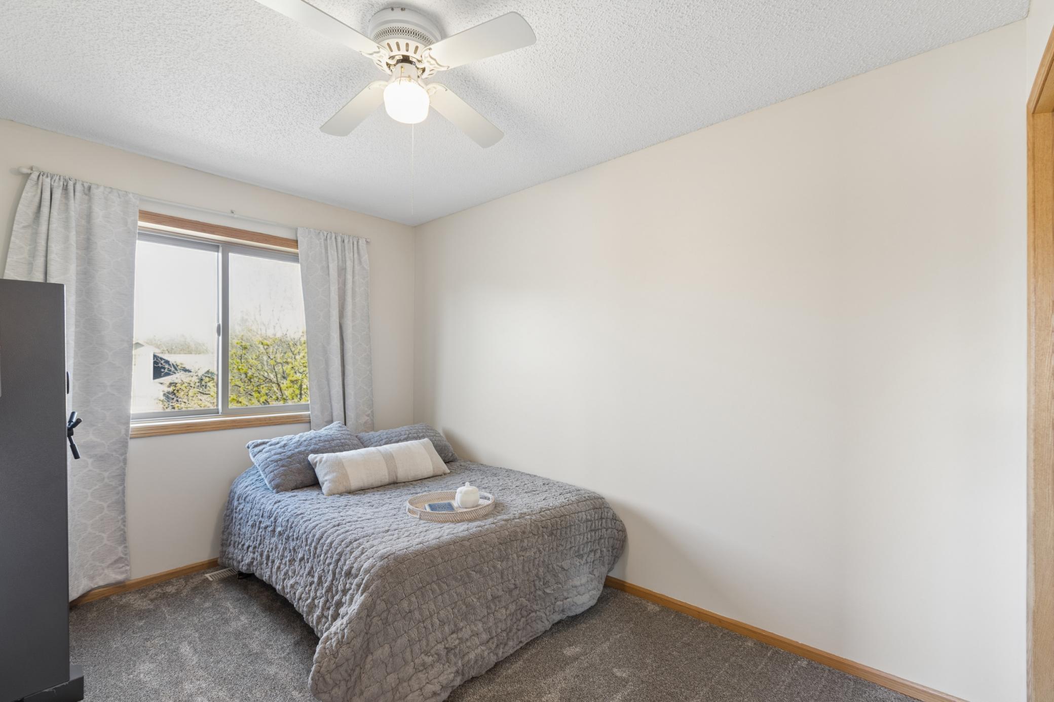 upper bedroom two with neutral paint and ceiling fan