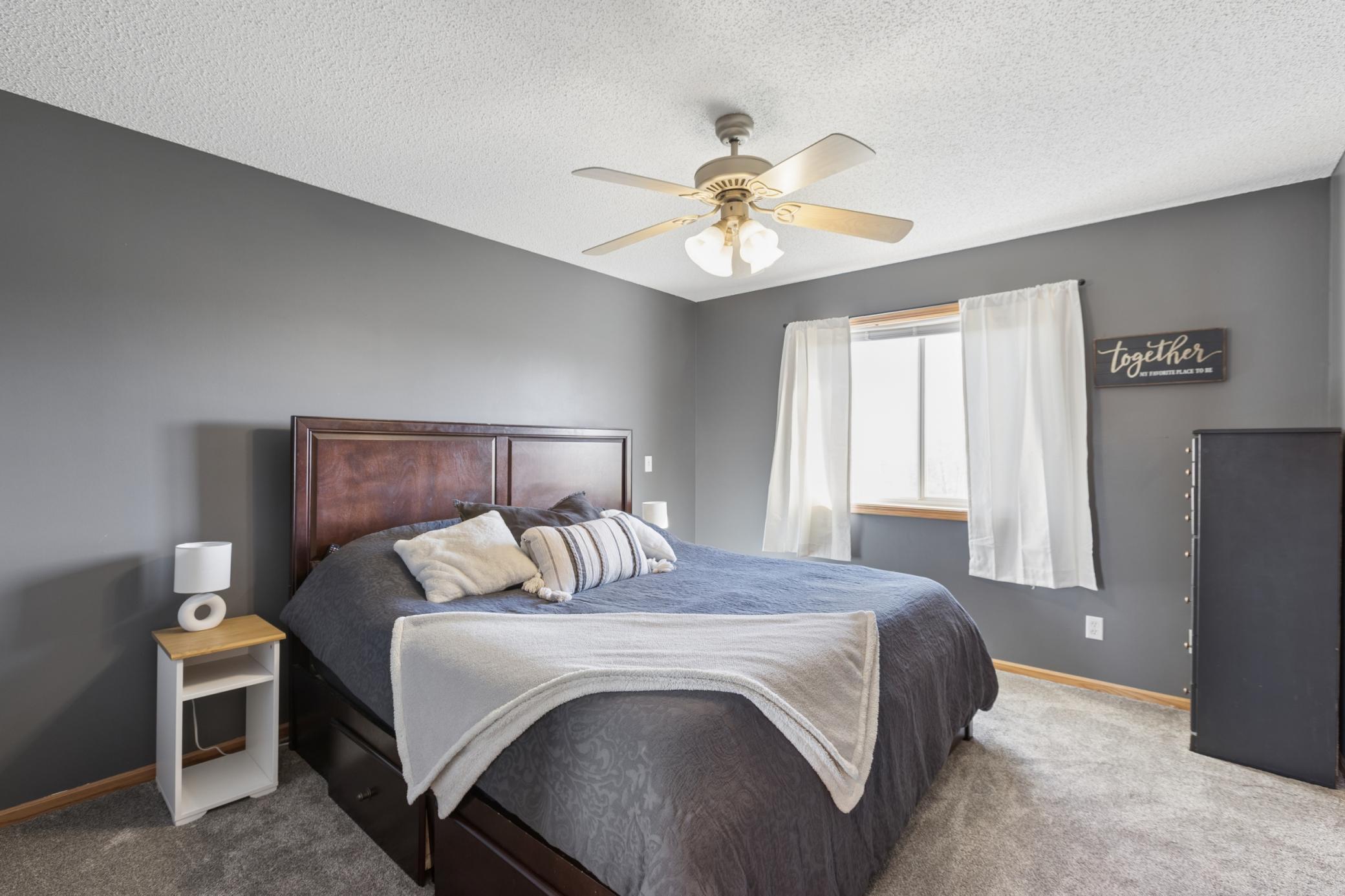 Primary bedroom is one of three bedrooms on the upper level! Large window overlooking the backyard, ceiling fan for extra comfort, and a large walk-in closet