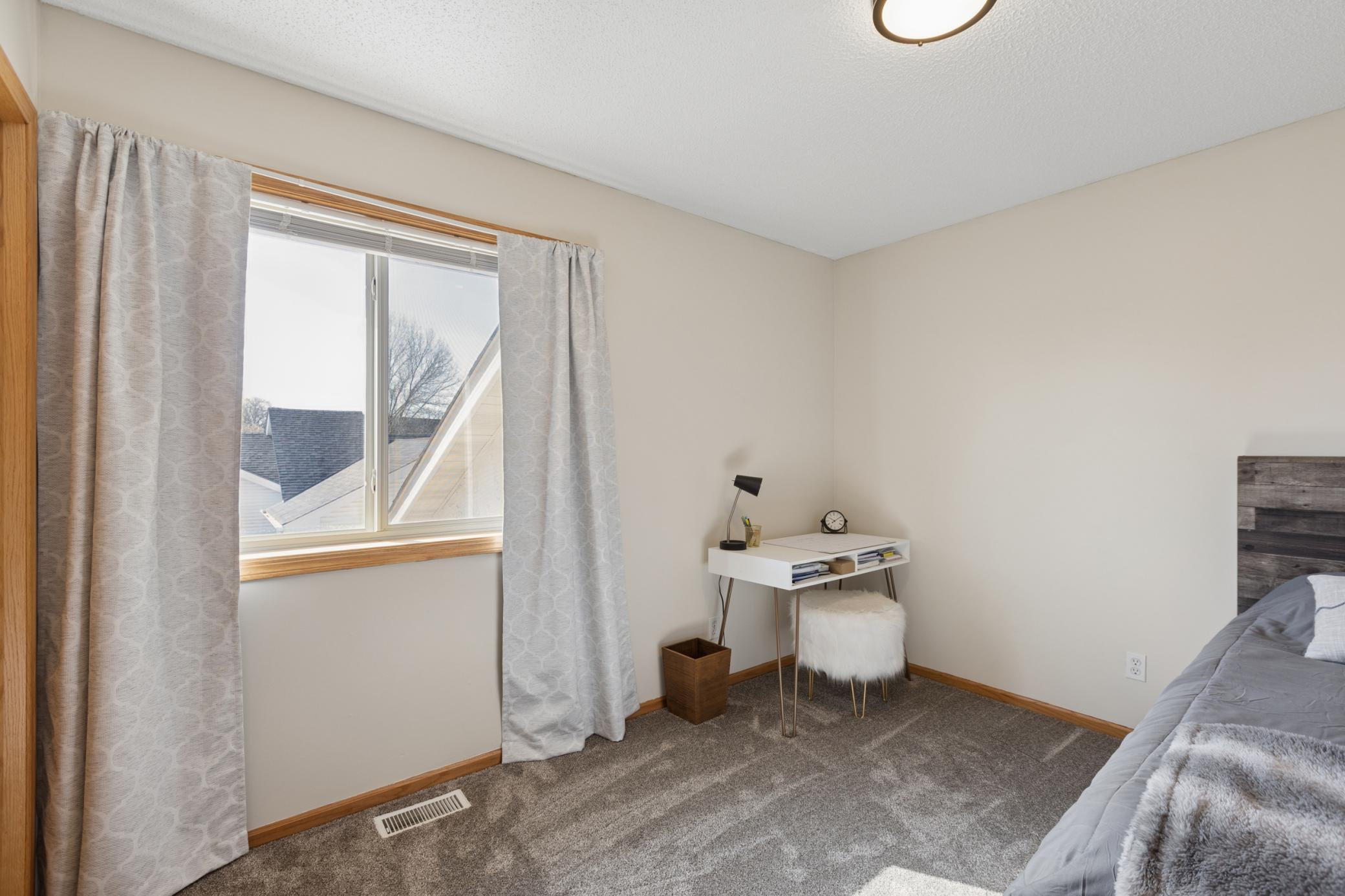 third upper level bedroom with neutral paint and plush carpeting