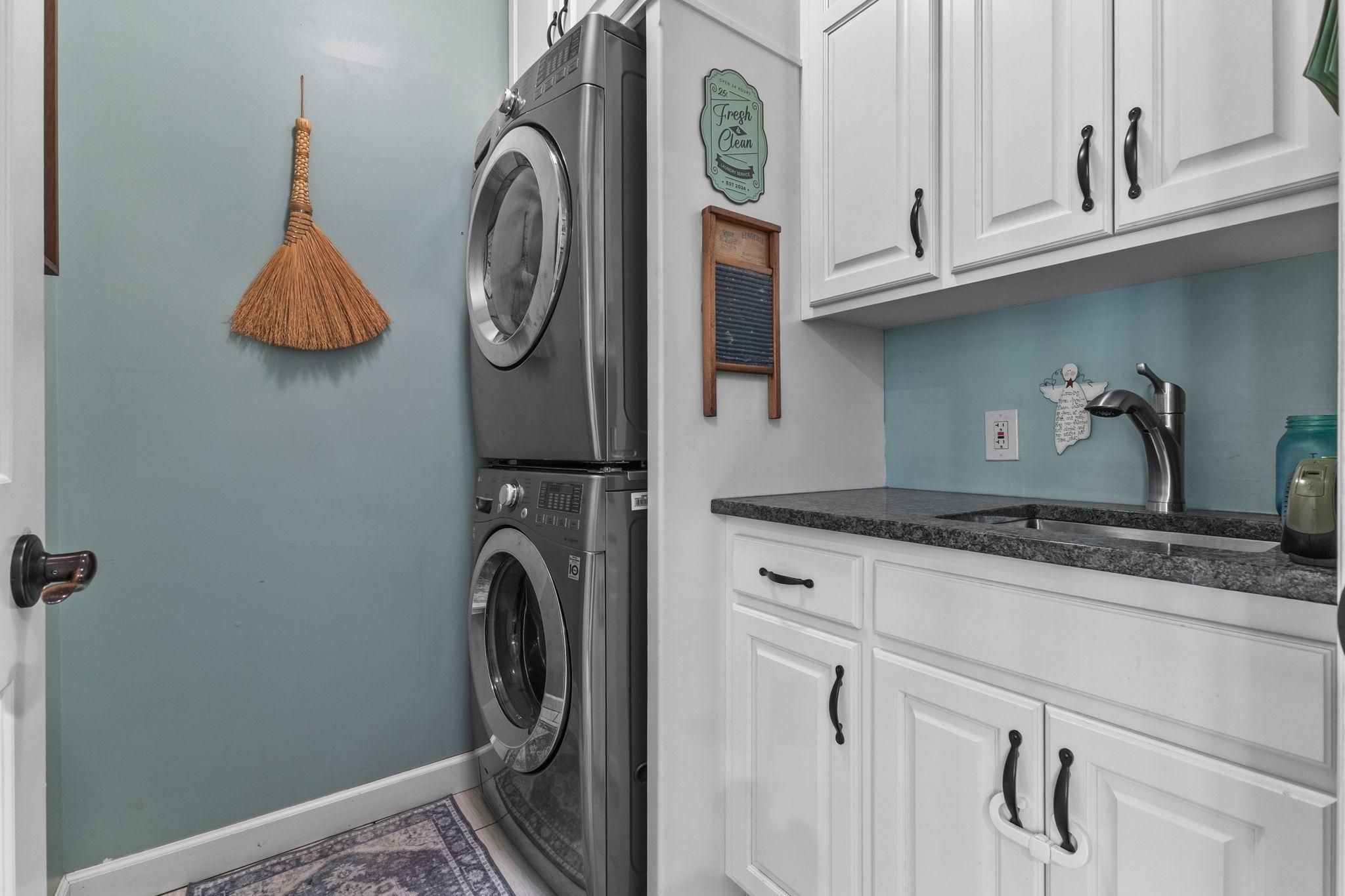 Main floor laundry with utility sink and tons of cabinets/storage