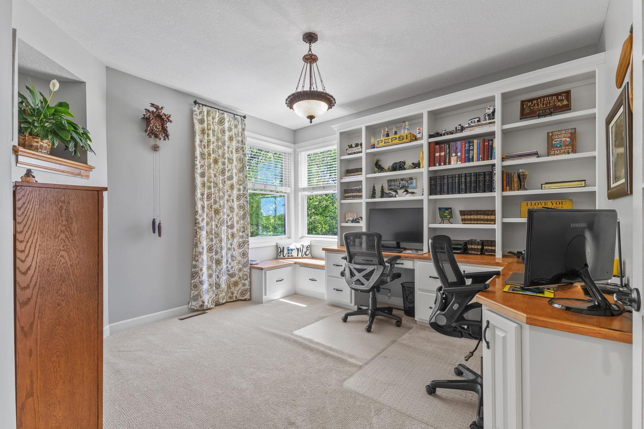 Main floor office with a ton of shelving and a sunny window seat