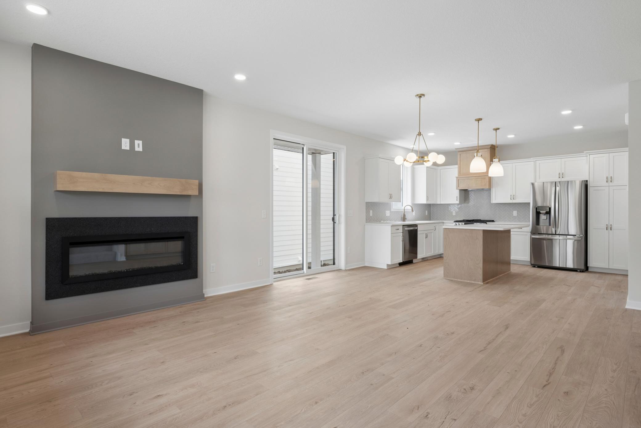 Gourmet kitchen design showcases painted white cabinetry, stained wood hood and island, herringbone backsplash and marble-look quartz countertops.