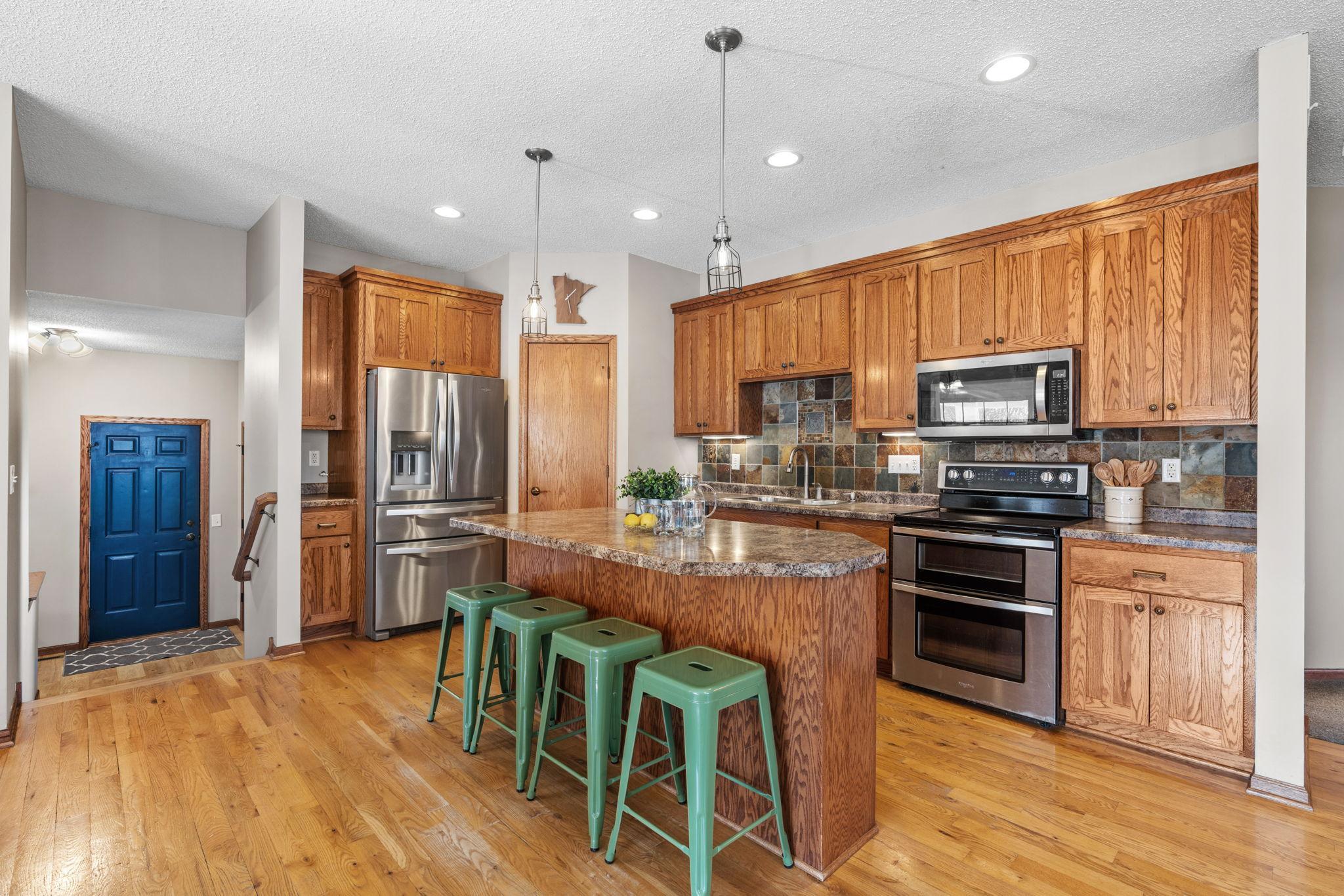 Spacious center island kitchen with stainless steel appliances and abundant cabinetry.