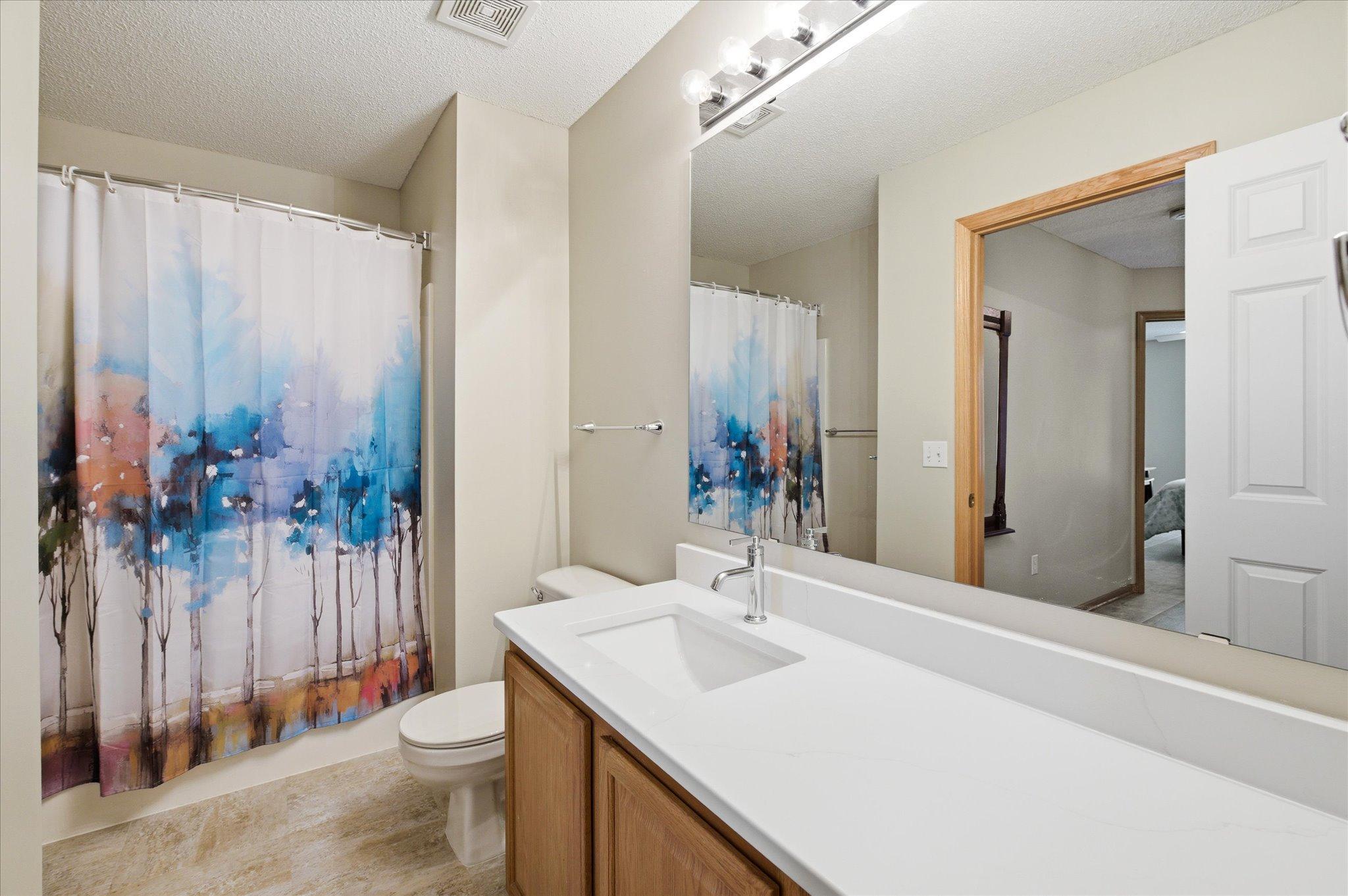 Bright and updated, the upper-level full bathroom features refreshed finishes including beautiful quartz countertops.