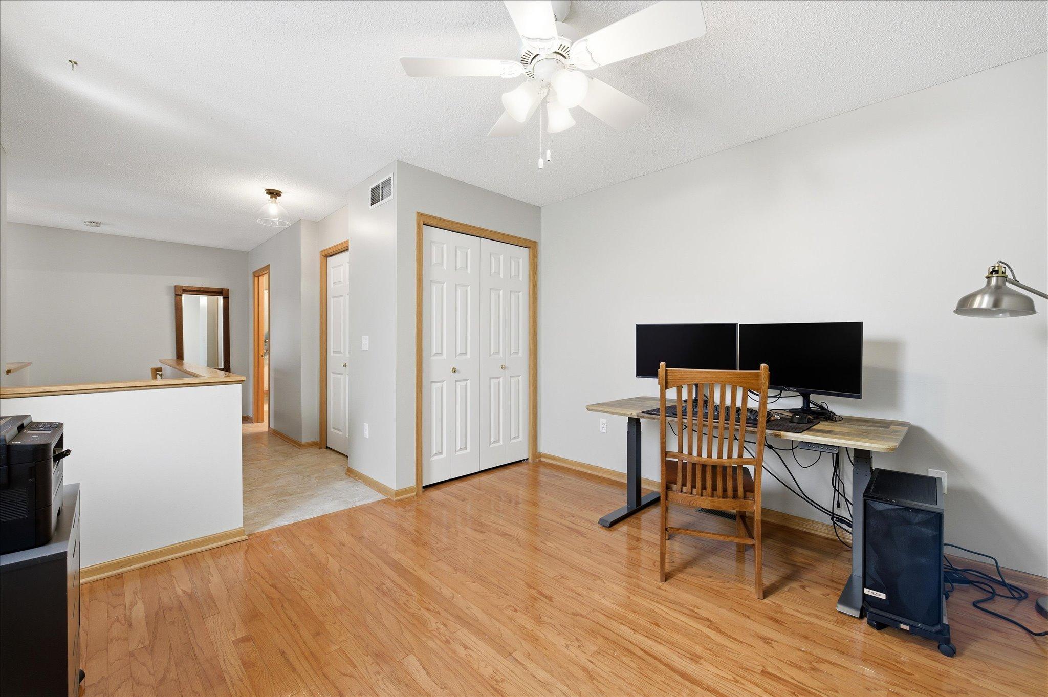 The upper-level hallway leads comfortably to both bedrooms while overlooking the bright main living space below.