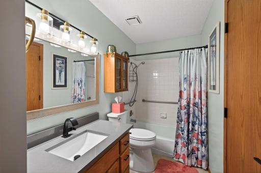 Updated, sparkling full bath with new light fixture, mirror, wall cabinet and towel bars!