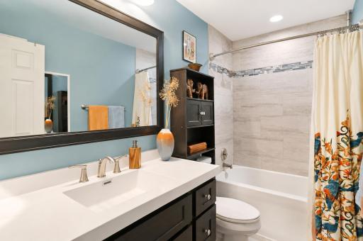 Full bath in hallway between bedrooms, featuring tiled shower.