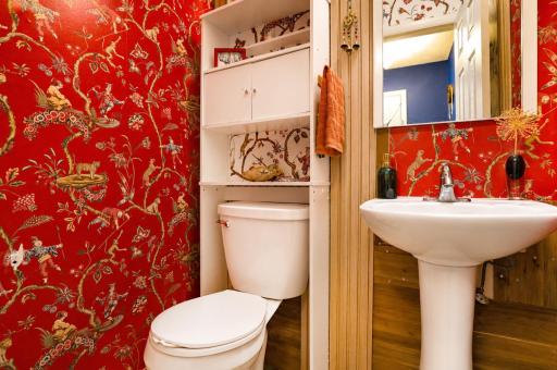 Adorable "powder room" next to kitchen, with well-selected wallpaper & decorative finishes.