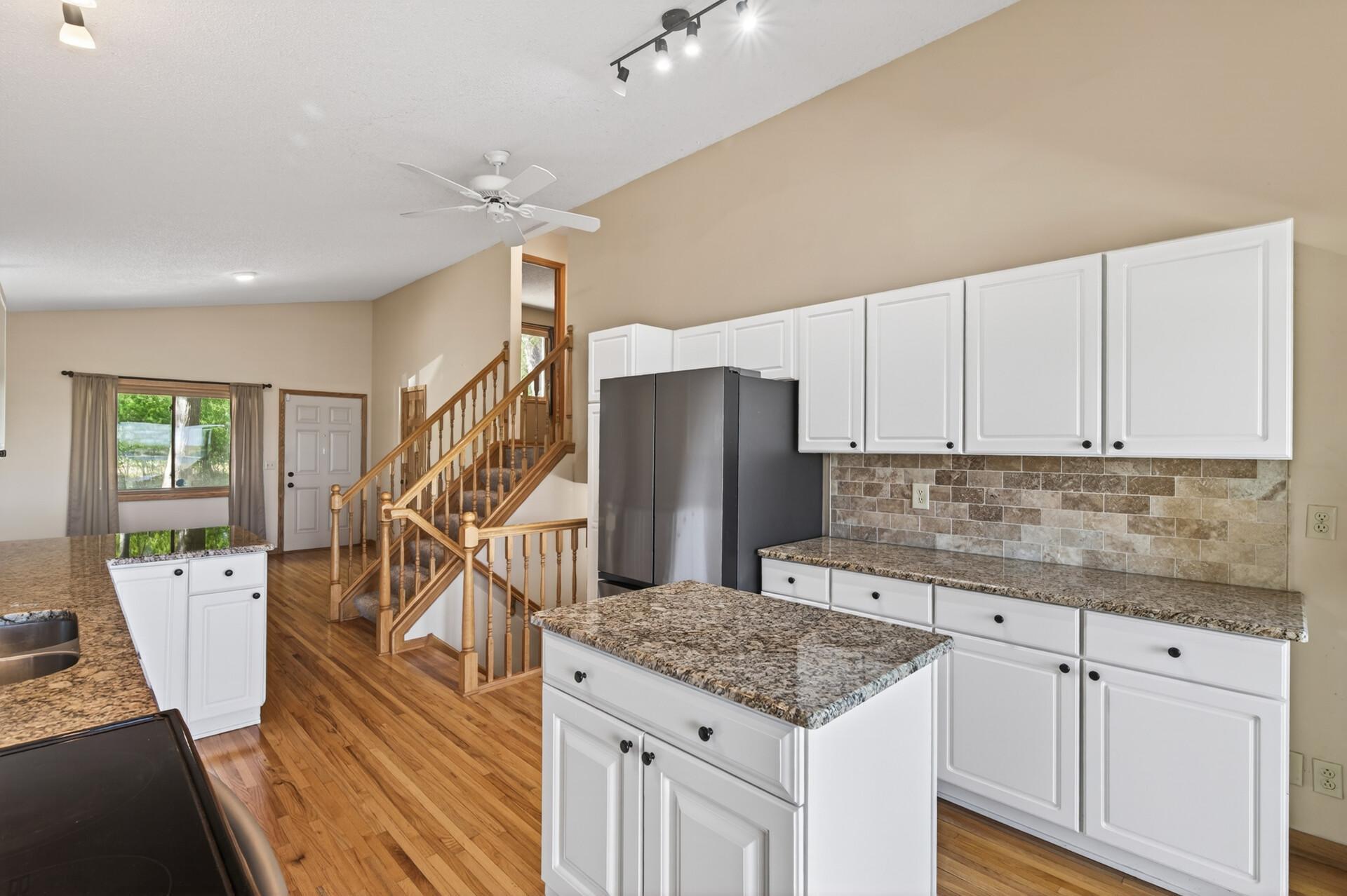 Beautifully updated kitchen with granite countertops, tiled backsplash, hardwood floors and newer stainless steel appliances.