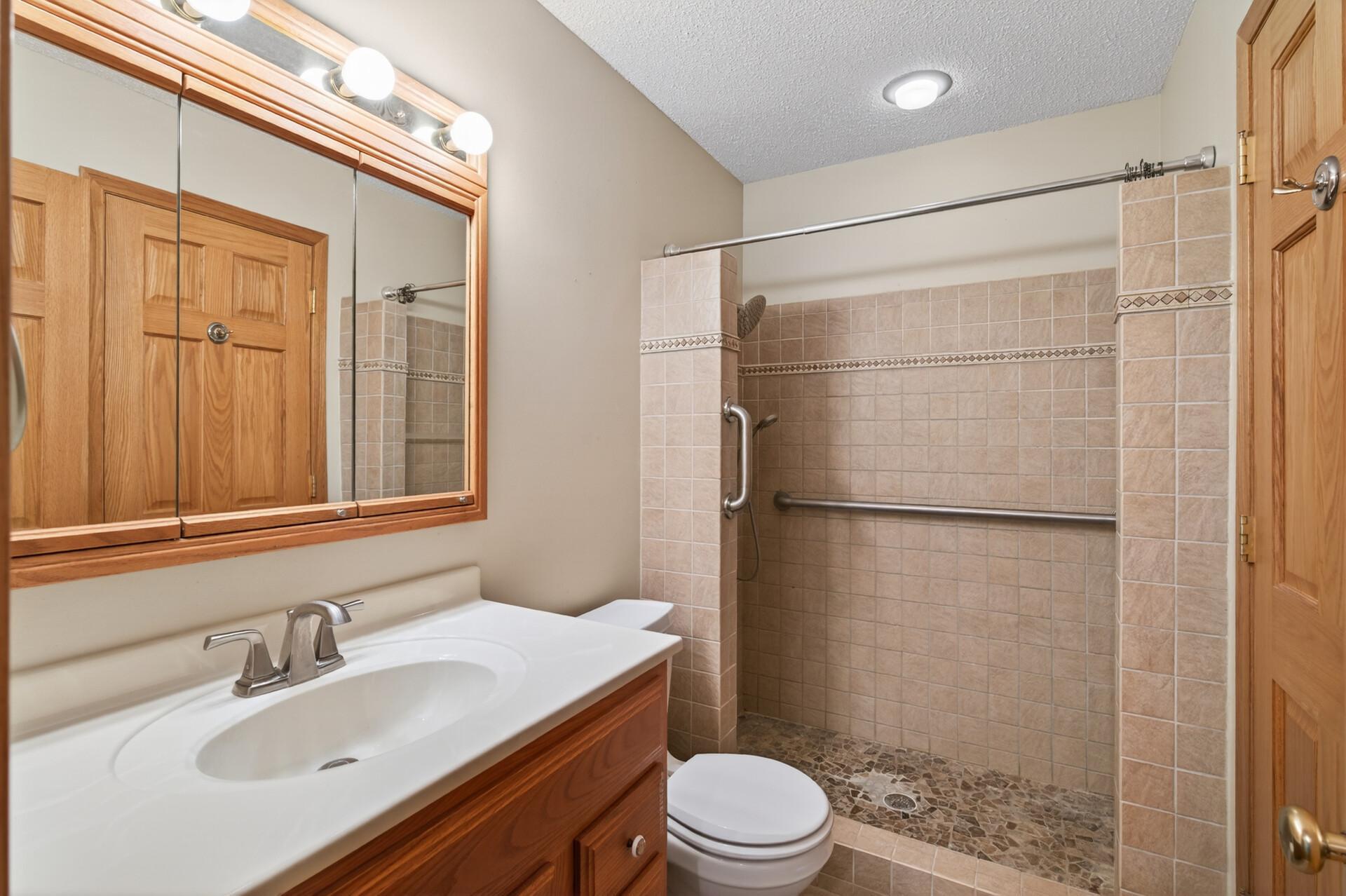 Upper level 3/4 bathroom with tiled shower.