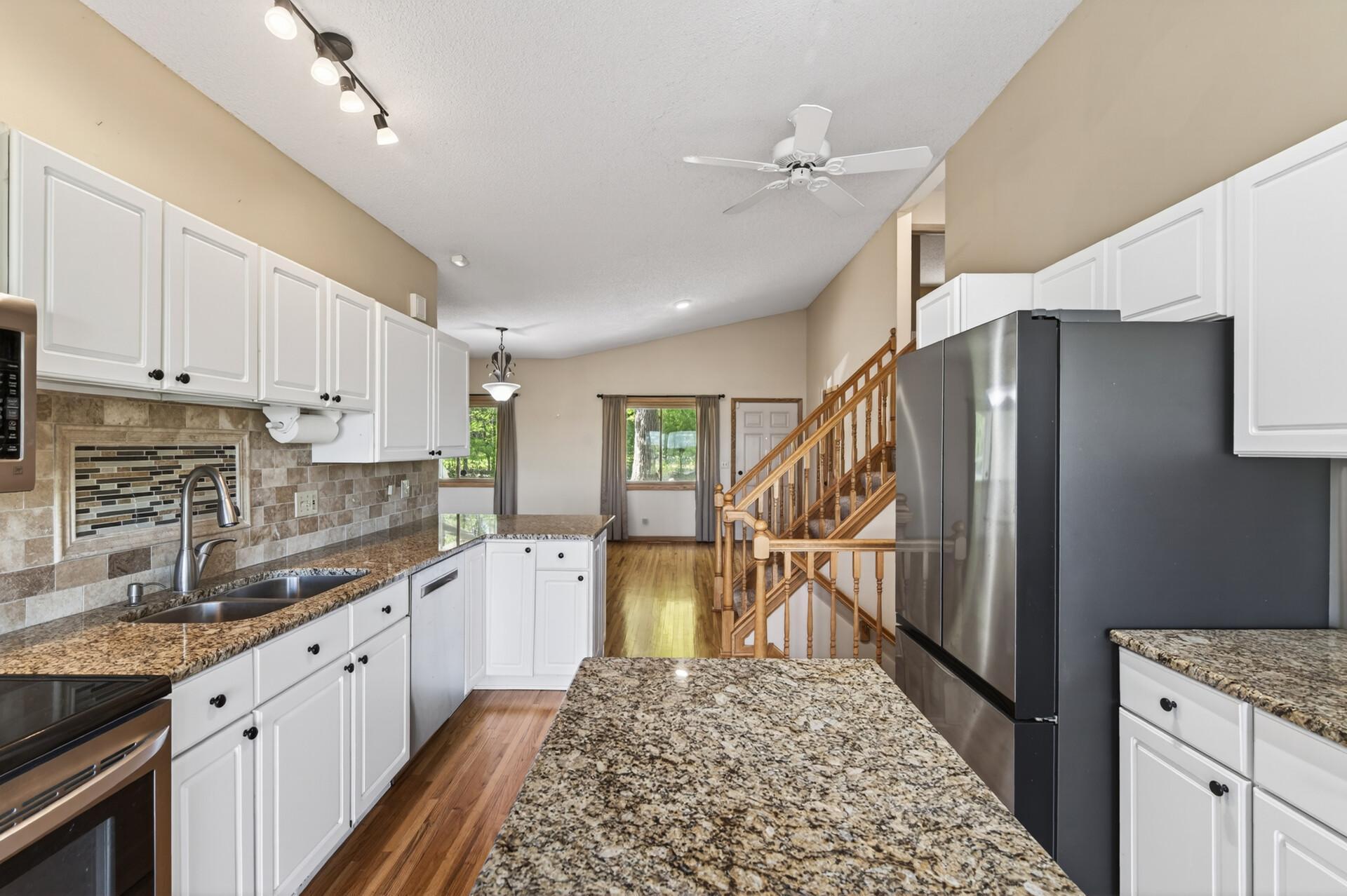 Beautifully updated kitchen with granite countertops, tiled backsplash, hardwood floors and newer stainless steel appliances.