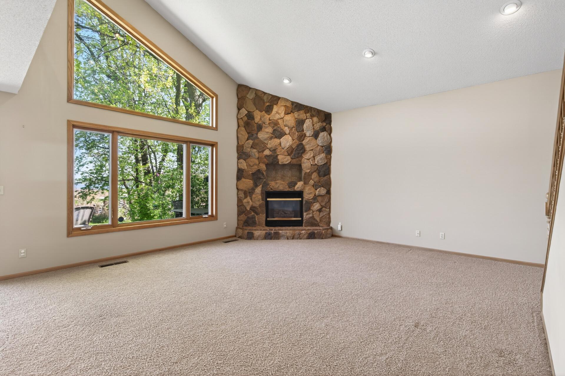 Vaulted ceiling with beautiful focal point of the floor-to-ceiling stone surround gas fireplace.