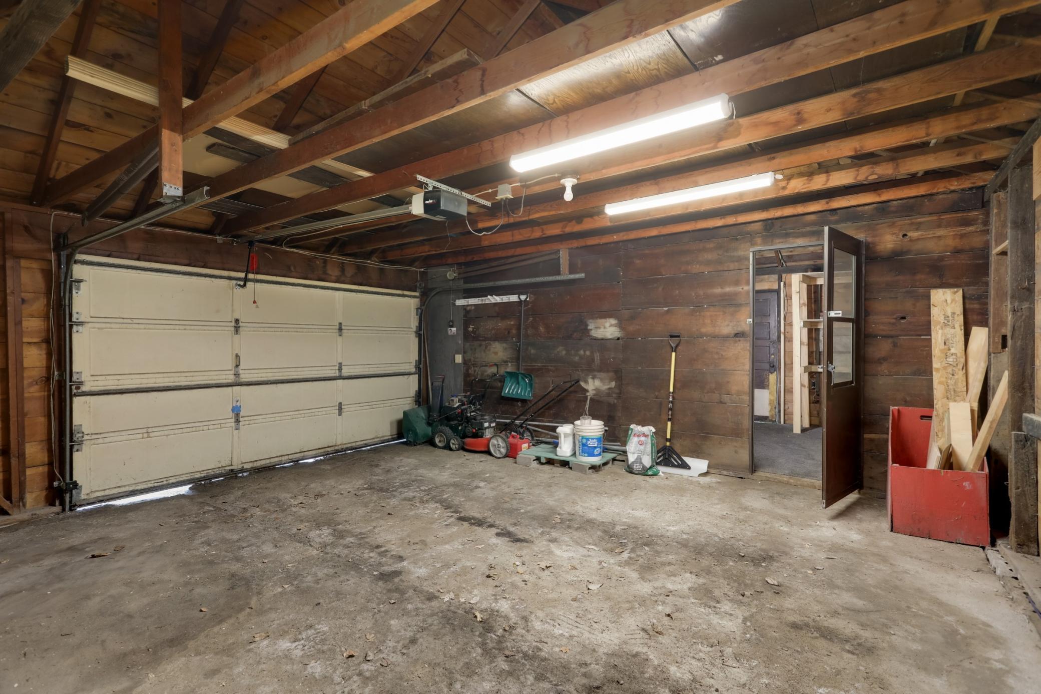 Interior parking area for 1-car of 19x20 with 12 ft wide x 6.5 ft height overhead garage door on opener, and storage room 10.5x9 accessible from either inside the garage area or from exterior left door inside the fenced yard.