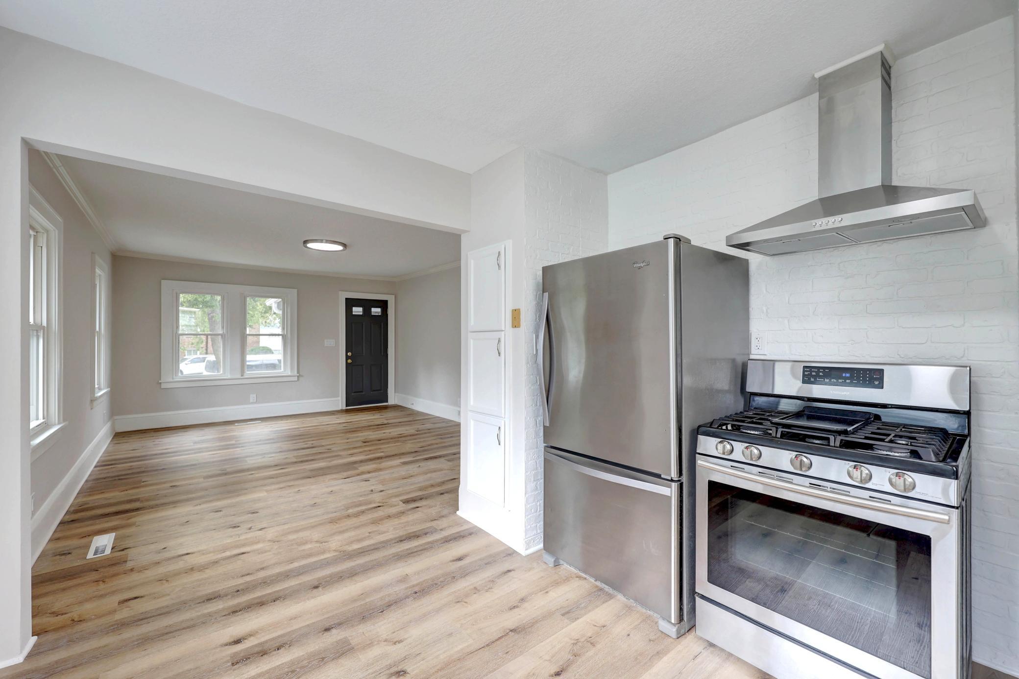 Another view from the Kitchen toward the Living Room showing off the New Whirlpool Refrigerator with Pull-out Drawers. The Stainless Hood is Functional and Sophisticated!