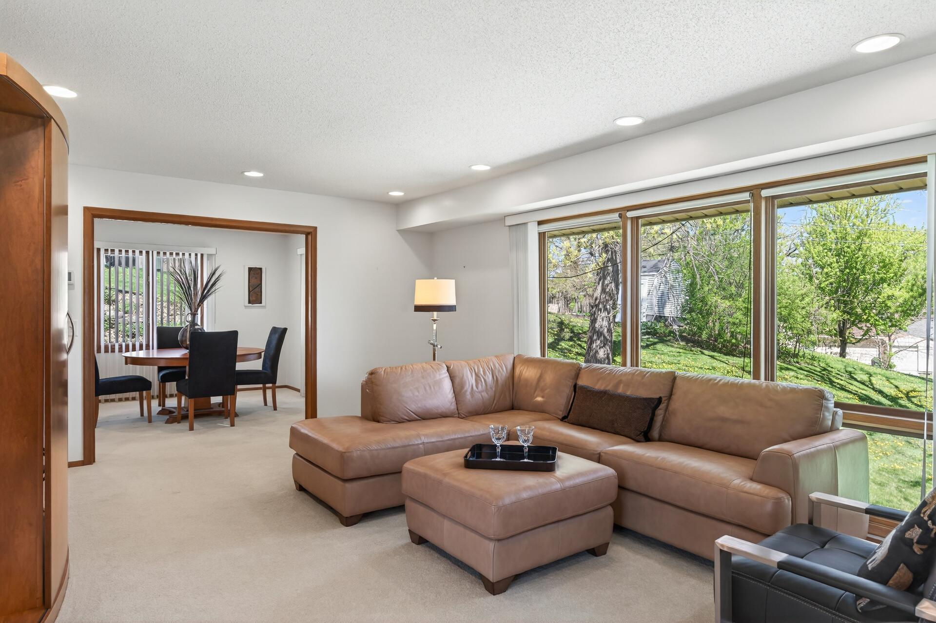 Floor to ceiling windows in the living room overlook the rolling back yard