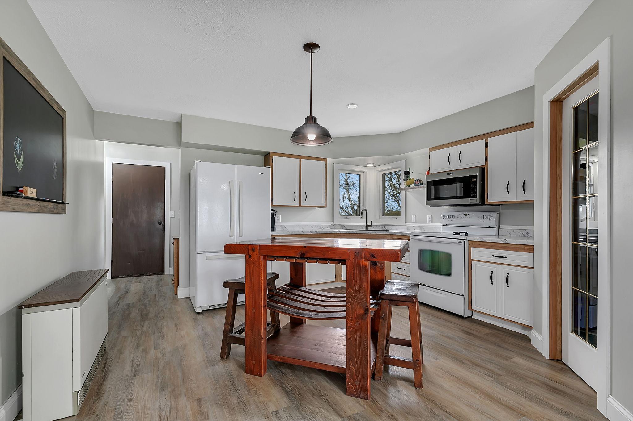 The kitchen, which boasts bright, sunny views overlooking the yard, has been freshly updated with new paint and flooring, and features a very spacious walk-in pantry!