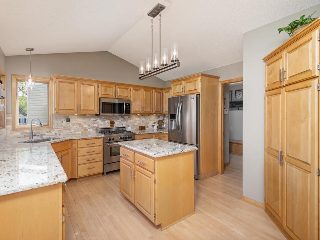 Notice the vaulted ceiling measuring 9’8” in height visually expands the space creating an open and inviting feel. The center island enhances functionality with added workspace, storage and a place to gather.
