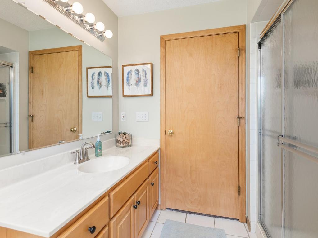 Lower-level bathroom measures 8'3" x 8'2" with newer toilet, faucet and showerhead.