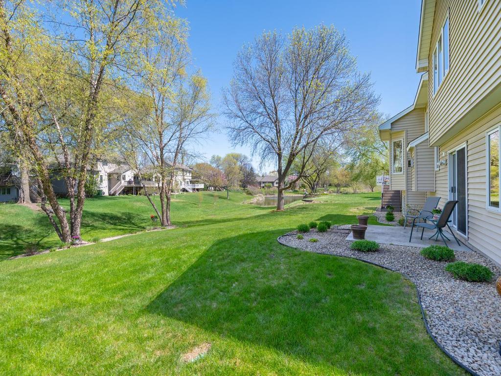 Pond views to the east complement the tastefully landscaped yard filled with carefully chosen trees, shrubs, and perennials nestled within beautifully edged rock gardens.