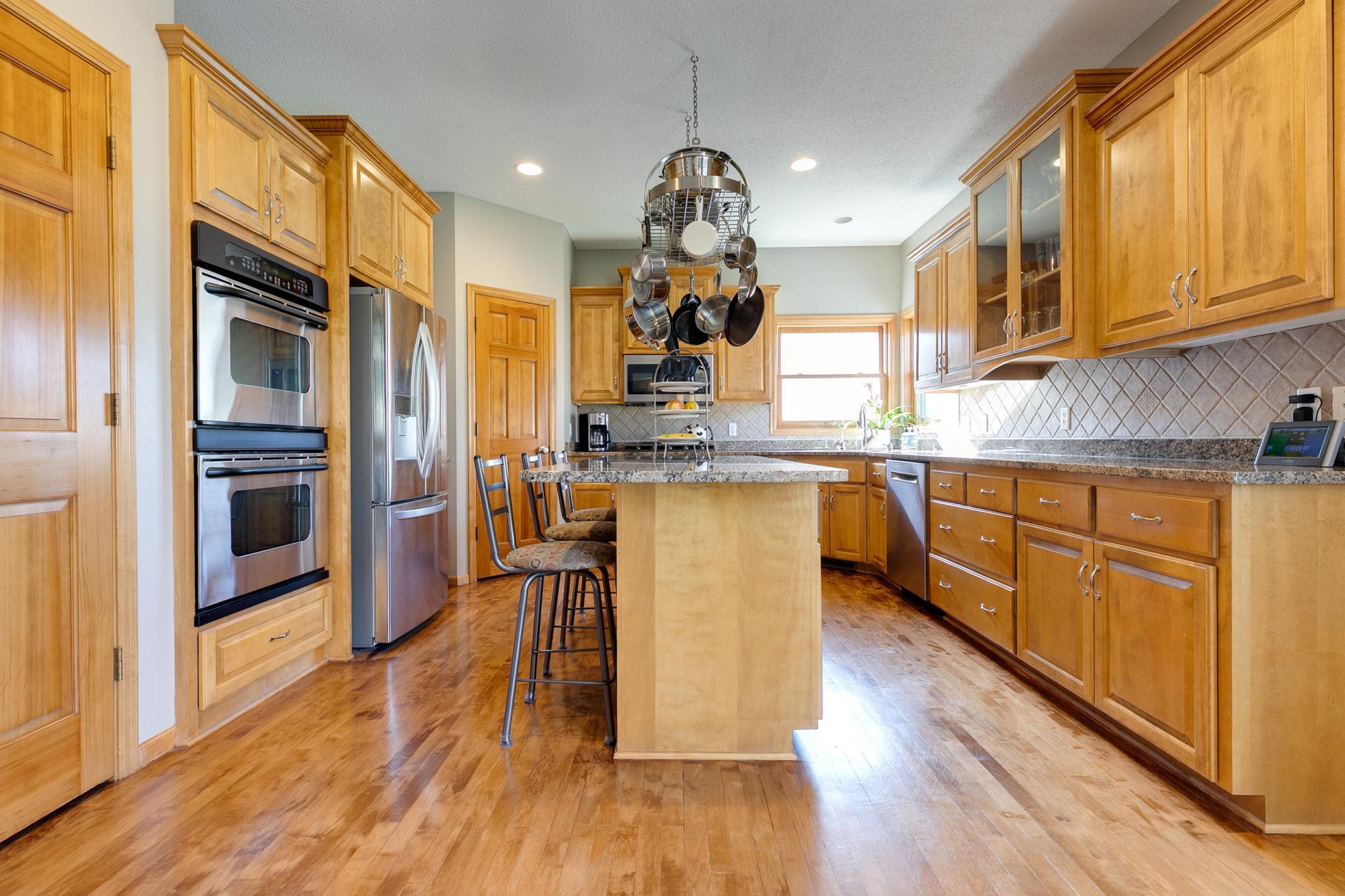 This kitchen features granite countertops (resealed in 2025), beautifully complemented by stainless steel appliances and a tile backsplash for a warm, polished look.