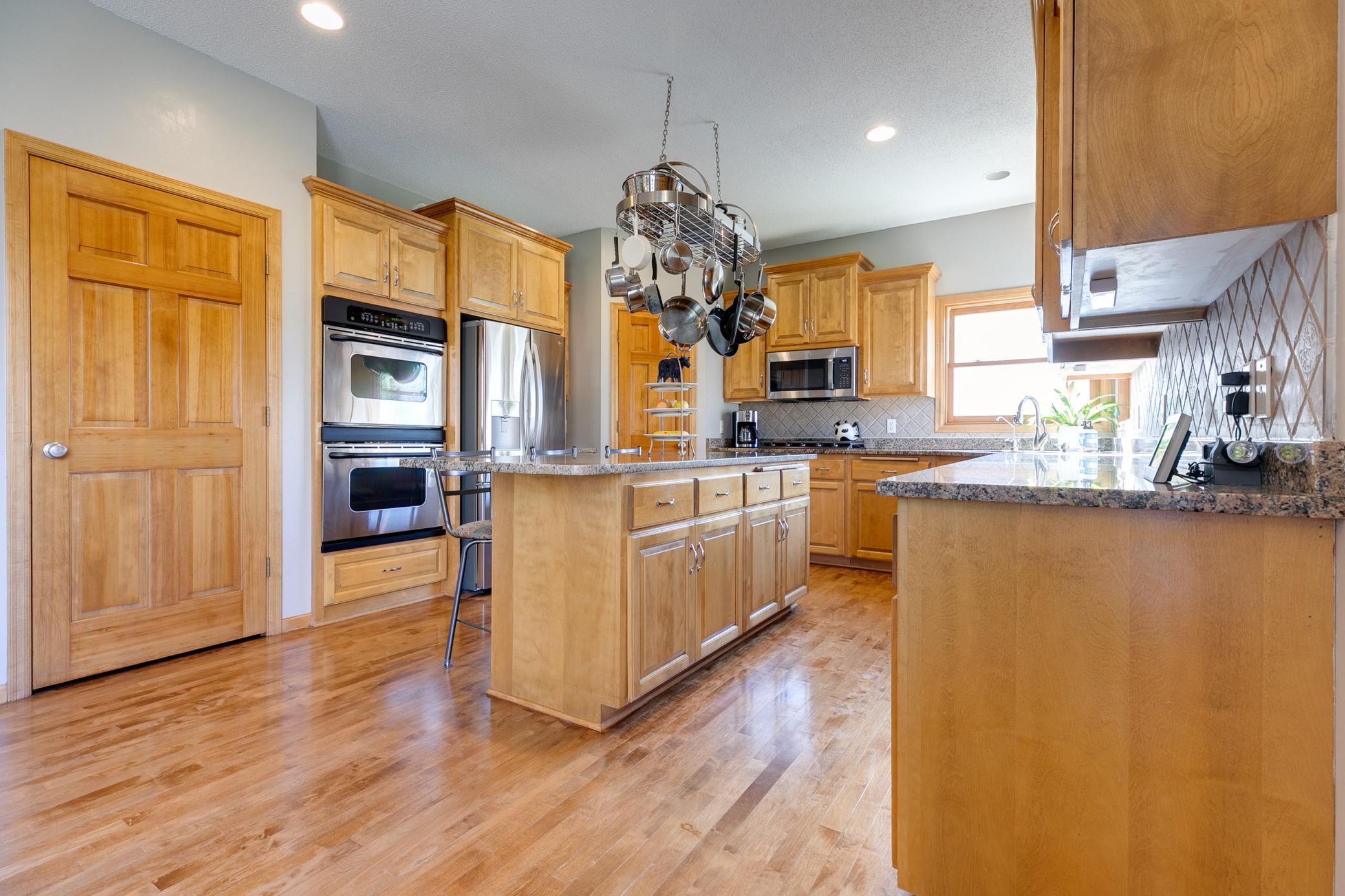 This kitchen is equipped with a five-burner gas range and a double wall oven, perfect for cooking and entertaining.
