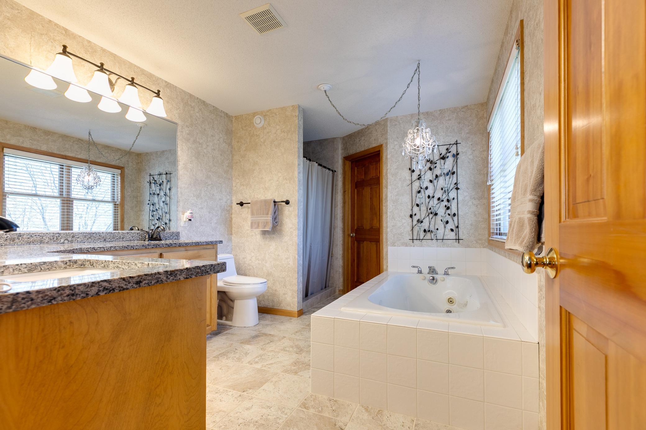 The master bathroom features a spacious walk-in closet, a separate shower and dual sinks. The granite countertops and toilet were replaced in 2020 and the bathroom tile flooring was also replaced in 2024.