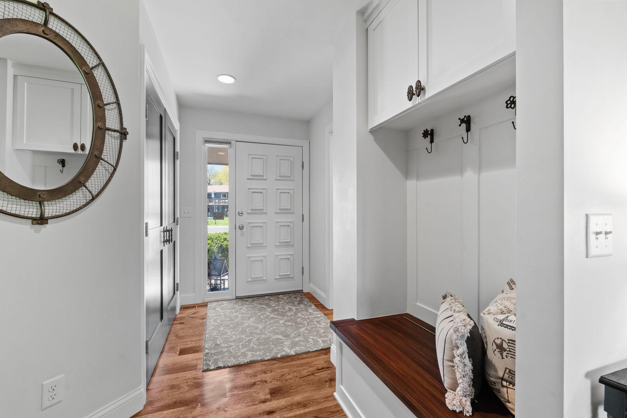 The foyer! Spacious coat closet, additional custom build bench & hooks and hardwood floors.