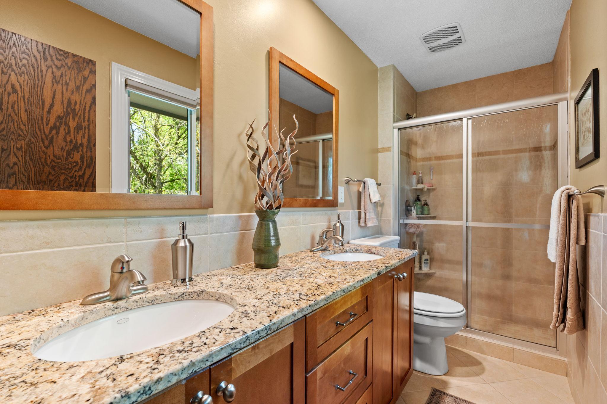 The private primary bath. Double vanity with granite countertops and walk in shower.