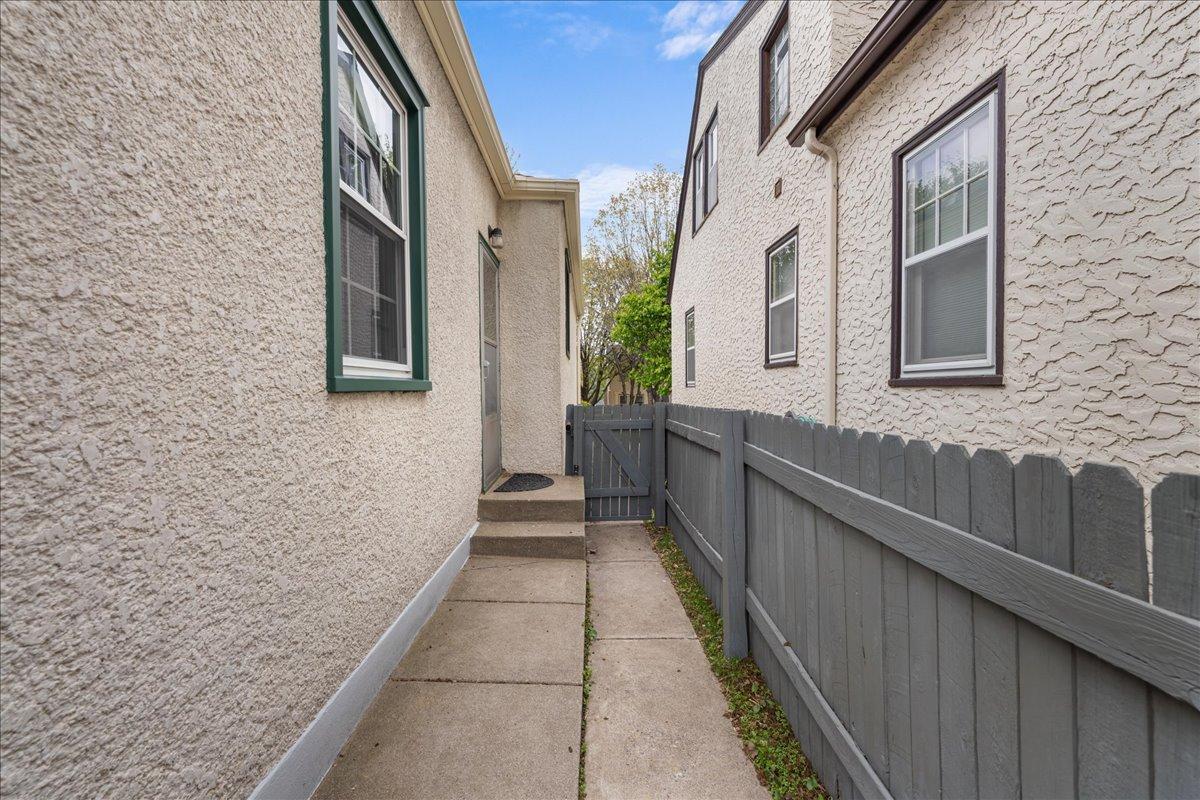 Side entrance into the kitchen from the backyard; fence was painted in 2018 and is in good condition