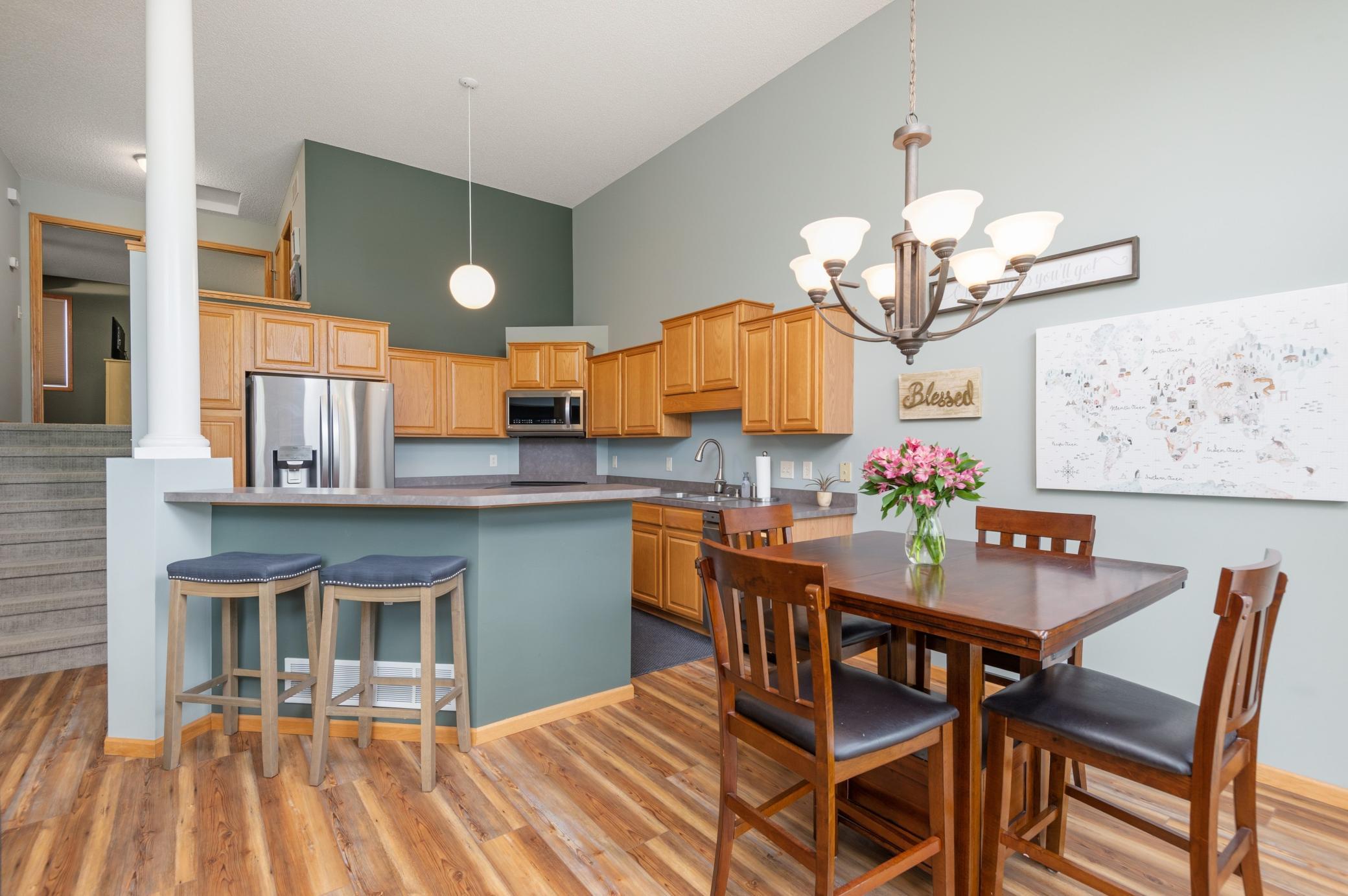 Kitchen with breakfast bar, stainless appliances, beautiful floors and ample cabinet space!