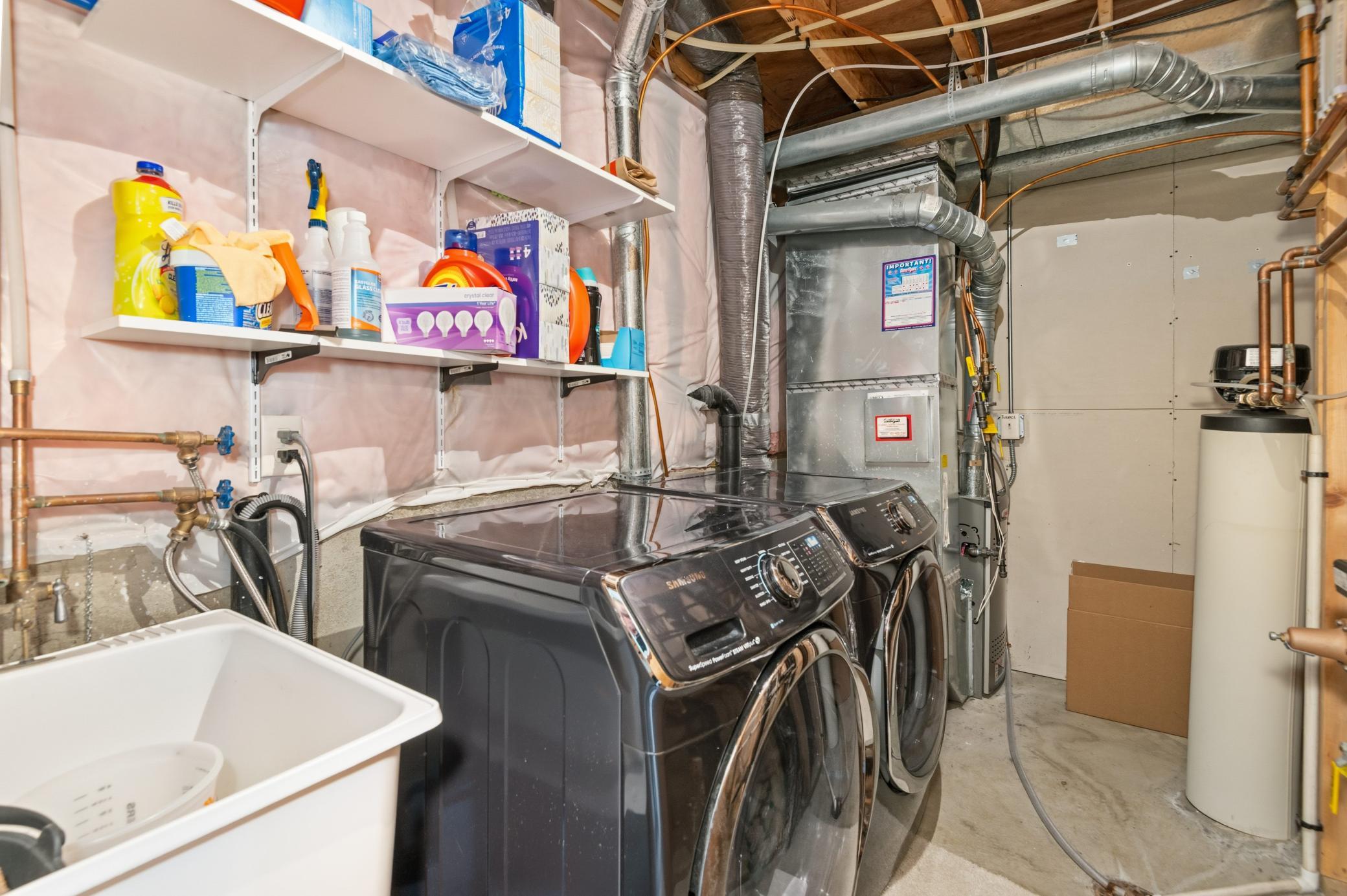 Lower-level utility room with newer furnace, washer/dryer and utility sink!