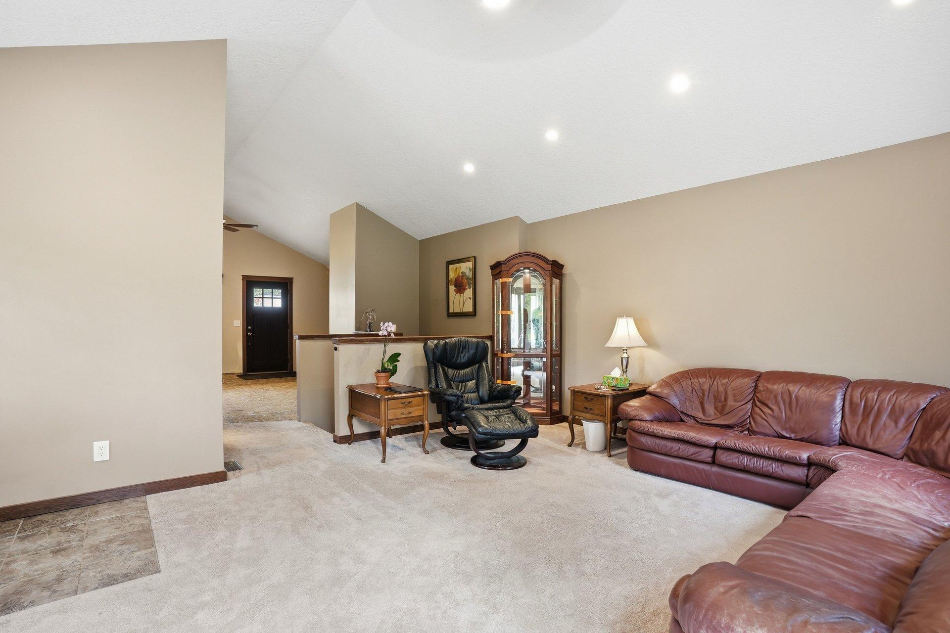 Spacious vaulted living room filled with natural light and overlooking the stunning backyard — creating the perfect blend of openness, comfort, and beautiful views year-round.