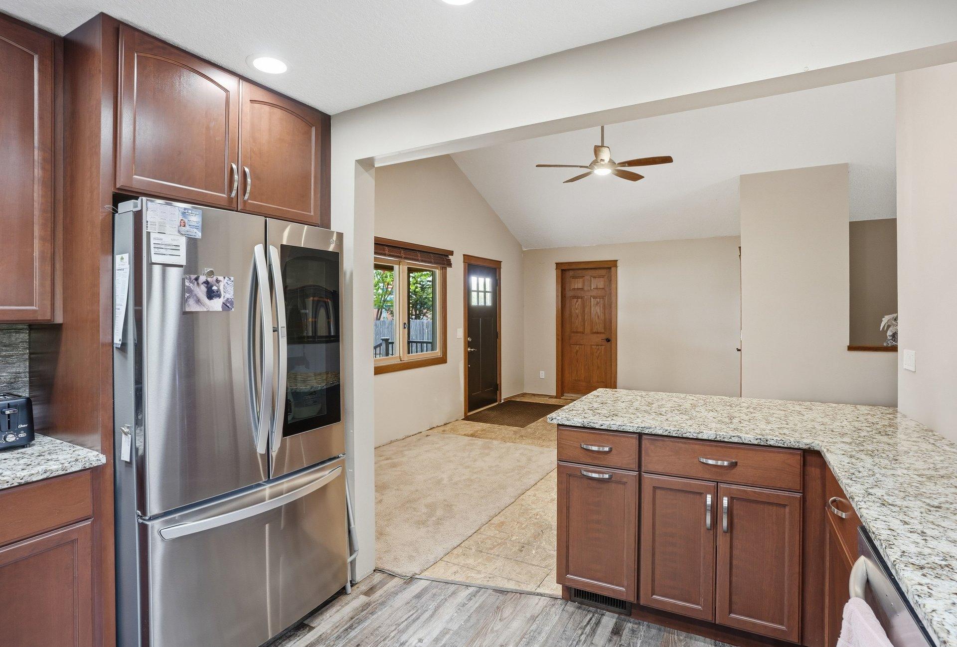 Beautifully updated kitchen featuring rich dark cabinetry, granite countertops, stainless steel appliances, and timeless finishes that blend style and functionality perfectly.