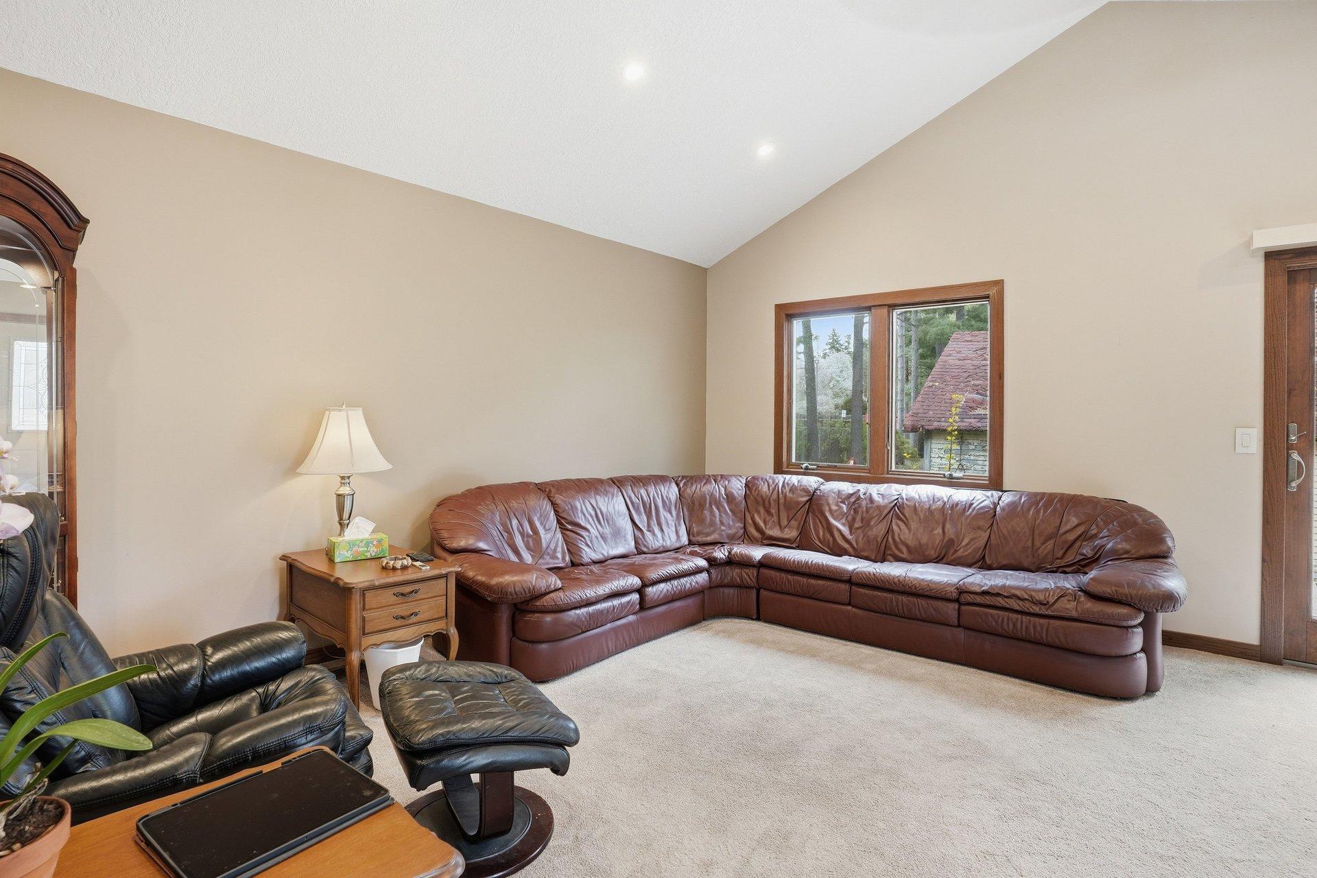 Spacious vaulted living room filled with natural light and overlooking the stunning backyard — creating the perfect blend of openness, comfort, and beautiful views year-round.