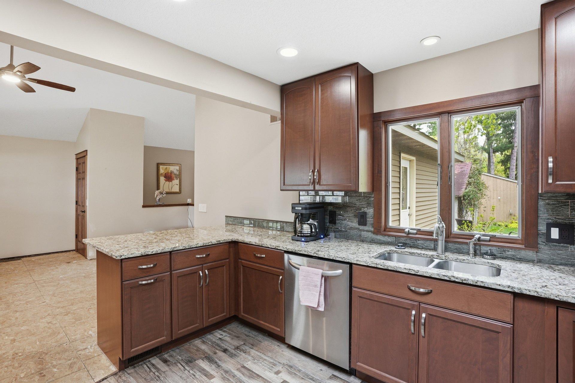Beautifully updated kitchen featuring rich dark cabinetry, granite countertops, stainless steel appliances, and timeless finishes that blend style and functionality perfectly.